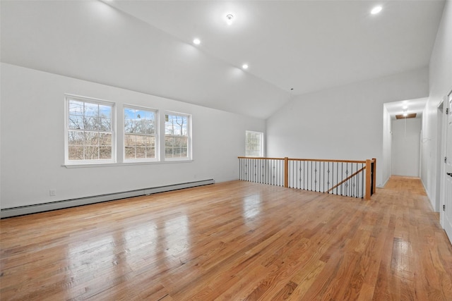 unfurnished room with lofted ceiling, light wood-style flooring, a baseboard heating unit, and recessed lighting