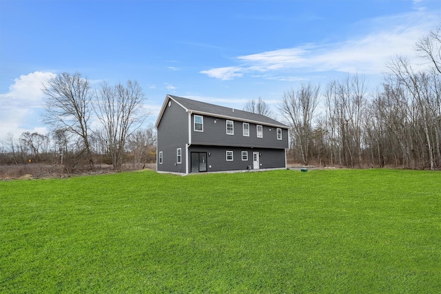 rear view of house featuring a lawn