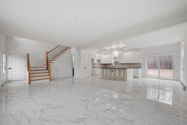 unfurnished living room featuring marble finish floor, a baseboard heating unit, and stairway