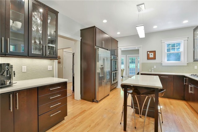 kitchen with light countertops, stainless steel fridge, and dark brown cabinetry