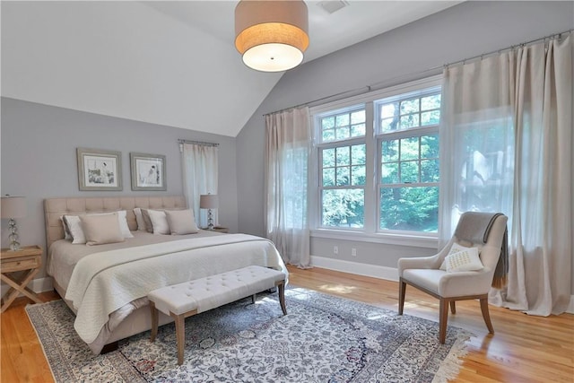 bedroom featuring vaulted ceiling, wood finished floors, and baseboards