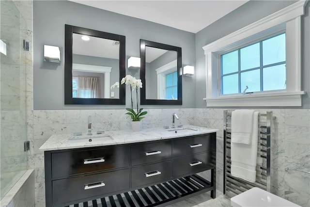 bathroom featuring double vanity, an enclosed shower, a sink, and tile walls