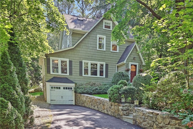 view of front of property with a garage, driveway, and a shingled roof