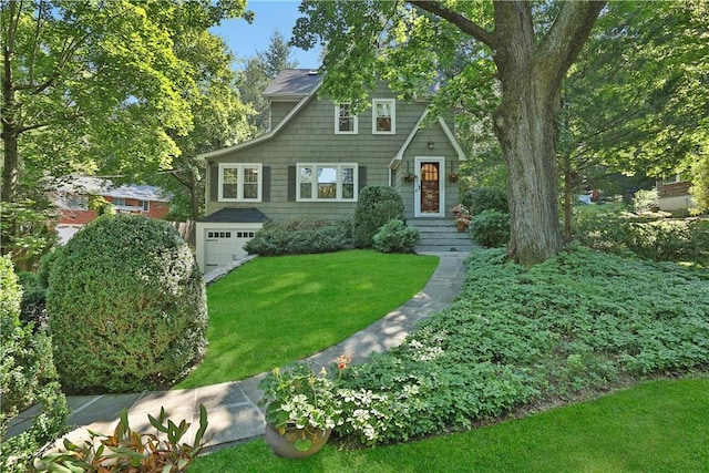 view of front of property featuring an attached garage and a front lawn