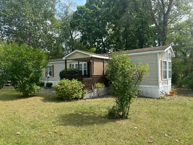 back of house with a wooden deck and a lawn