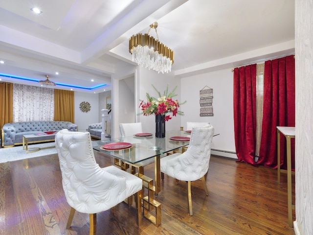 dining area featuring baseboard heating, dark wood-type flooring, and ceiling fan with notable chandelier