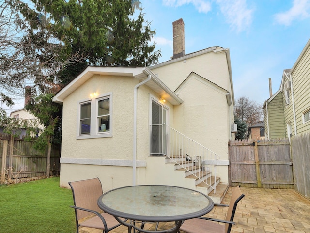 rear view of property with a lawn and a patio