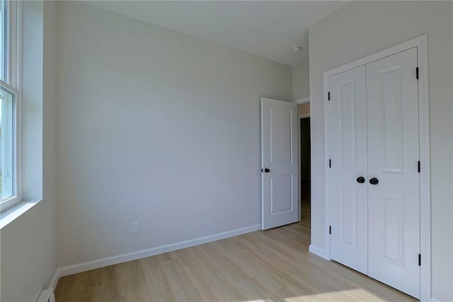 unfurnished bedroom with light hardwood / wood-style floors and a closet