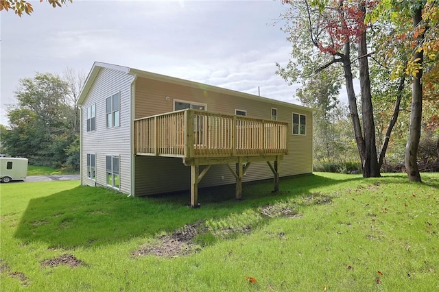 rear view of property featuring a wooden deck and a yard