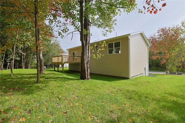 view of side of home featuring a yard and a wooden deck