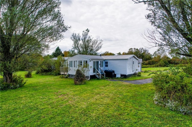 rear view of house featuring a yard