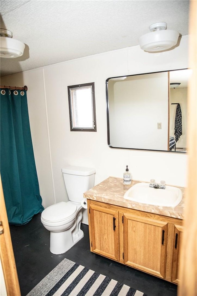 bathroom with vanity, a textured ceiling, and toilet