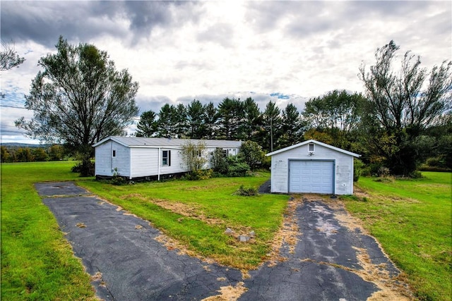 view of front of property with a front yard, a garage, and an outdoor structure