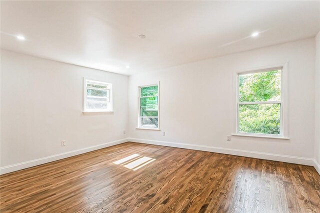 unfurnished room with a healthy amount of sunlight and dark hardwood / wood-style floors