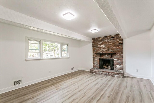 unfurnished living room with light wood-type flooring and a fireplace