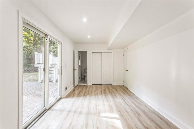 unfurnished bedroom with light hardwood / wood-style floors, access to exterior, and a closet