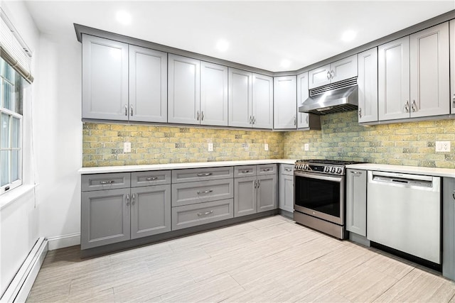 kitchen with baseboard heating, backsplash, gray cabinetry, and stainless steel appliances