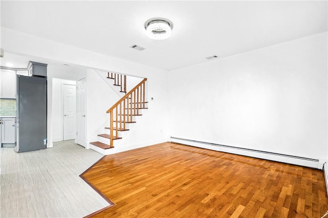 interior space with light wood-type flooring and a baseboard radiator