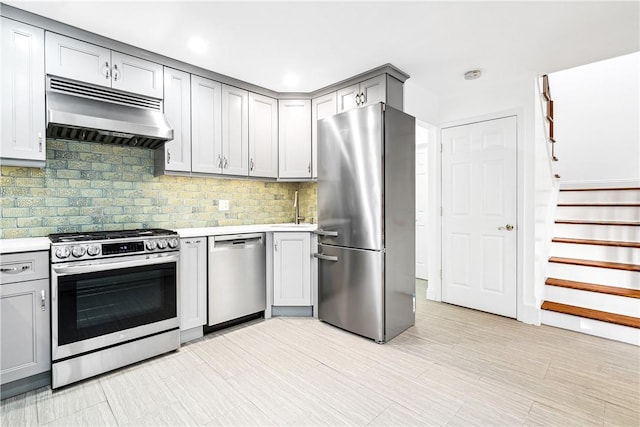 kitchen with decorative backsplash, gray cabinets, sink, and stainless steel appliances