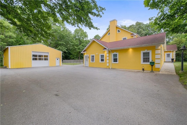 67 Myers Corners Rd, Wappingers Falls, NY 12590 - view of front of home with a detached garage, a chimney, an outbuilding, and stucco siding