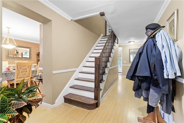 stairway featuring hardwood / wood-style floors and crown molding