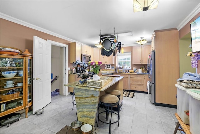 kitchen featuring light brown cabinets, a kitchen breakfast bar, crown molding, light stone countertops, and appliances with stainless steel finishes