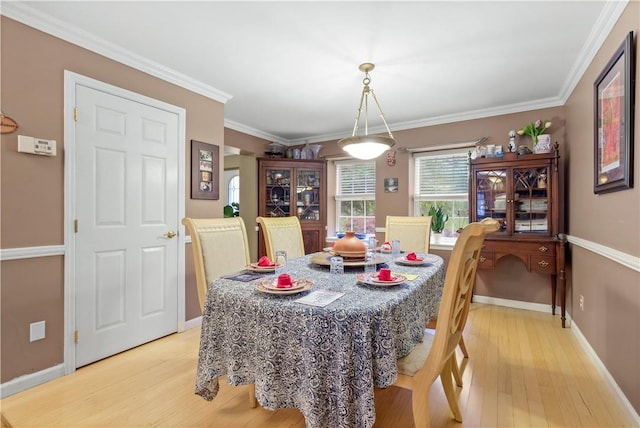 dining area with light hardwood / wood-style flooring and ornamental molding