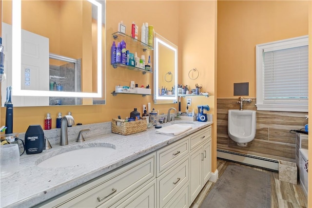 67 Myers Corners Rd, Wappingers Falls, NY 12590 - bathroom featuring baseboard heating, double vanity, tile walls, an enclosed shower, and wainscoting
