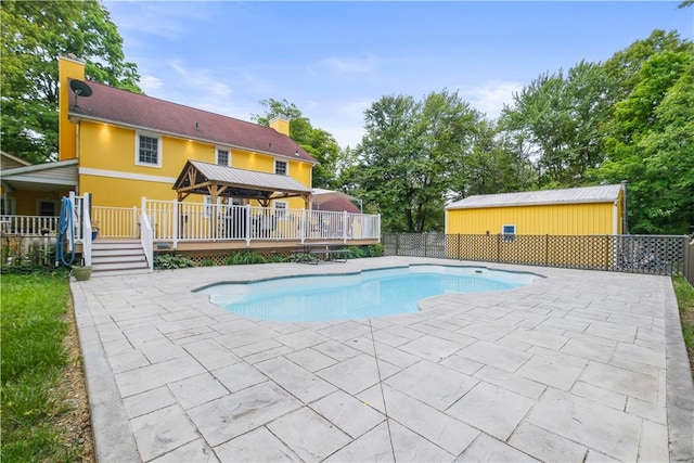 view of swimming pool featuring a deck and a patio area