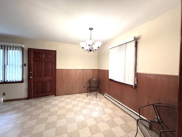 empty room featuring wood walls and a notable chandelier