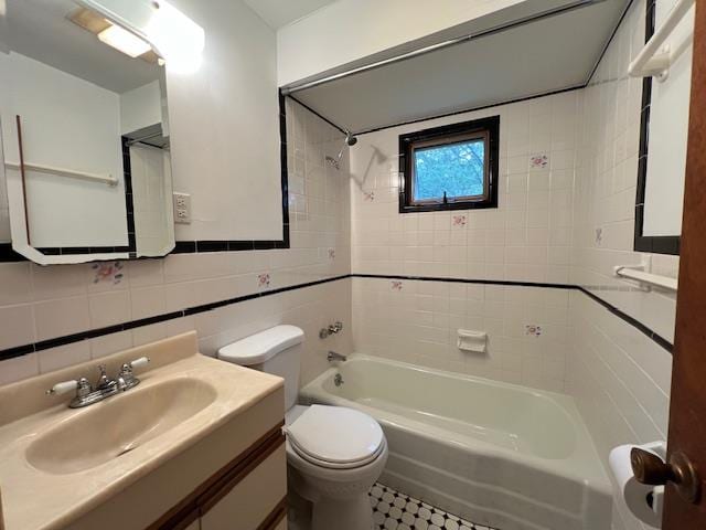 full bathroom featuring sink, tiled shower / bath, tile walls, and toilet