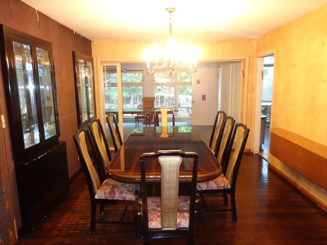 dining space featuring dark hardwood / wood-style flooring and an inviting chandelier