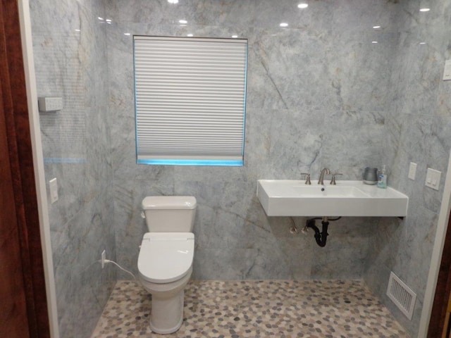 bathroom featuring sink, tile patterned flooring, tile walls, and toilet