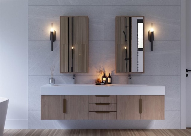 bathroom with hardwood / wood-style flooring, vanity, a bathtub, and tile walls