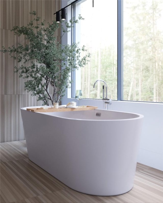 bathroom with hardwood / wood-style flooring and a bath