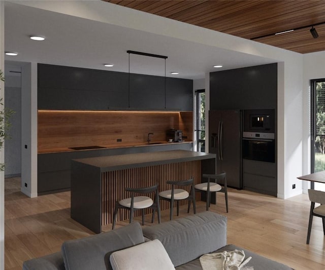 kitchen with wood ceiling, a breakfast bar, stainless steel appliances, and light wood-type flooring