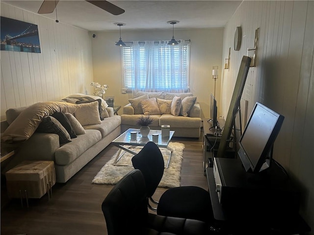 living room with wood walls, dark hardwood / wood-style floors, and ceiling fan