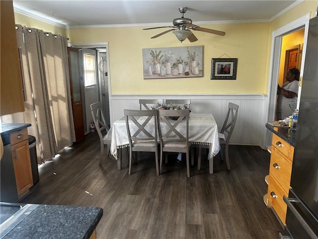 dining area with crown molding, ceiling fan, and dark wood-type flooring