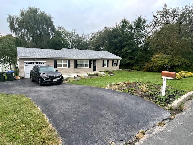 ranch-style house featuring driveway, a front yard, and an attached garage