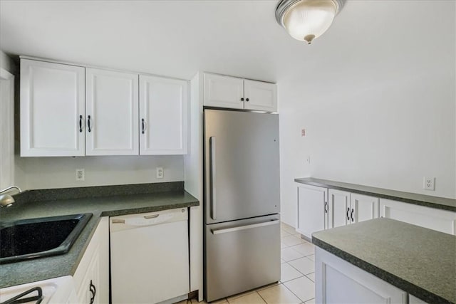 kitchen featuring white cabinets, light tile patterned floors, white appliances, and sink