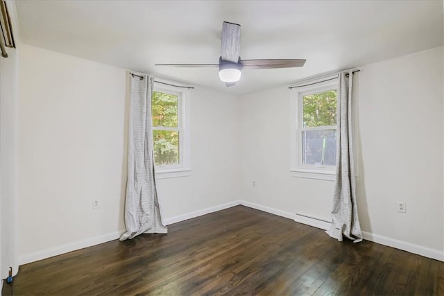 unfurnished room featuring baseboard heating, a wealth of natural light, ceiling fan, and dark hardwood / wood-style floors