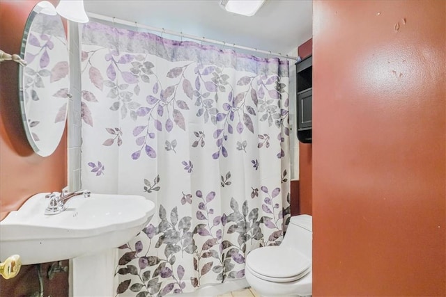 bathroom with a shower with curtain, toilet, and tile patterned floors