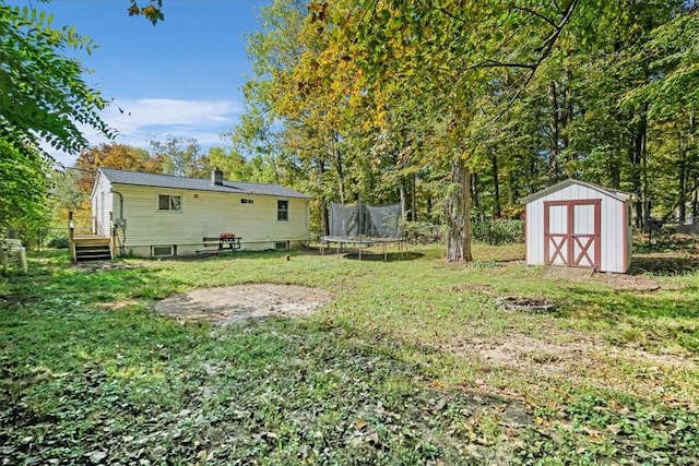 view of yard featuring a storage unit and a trampoline