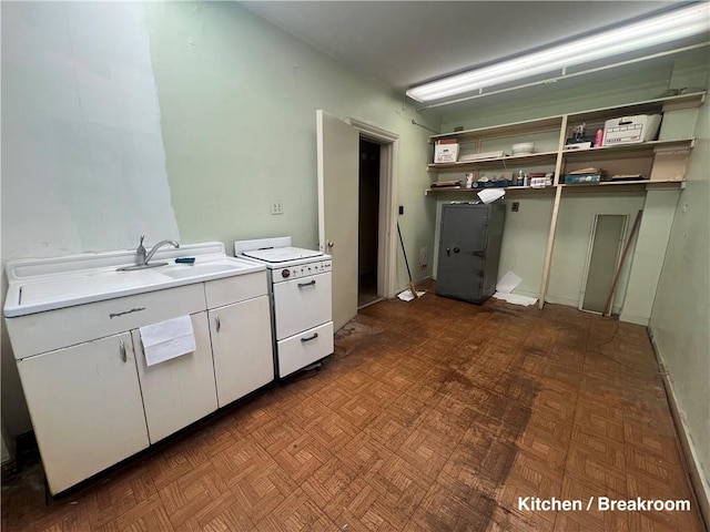 kitchen featuring dark parquet flooring, sink, white cabinets, and white range