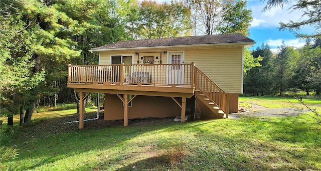 rear view of house with a lawn and a wooden deck