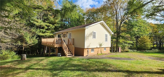 view of front of house featuring a front yard, central AC, and a wooden deck