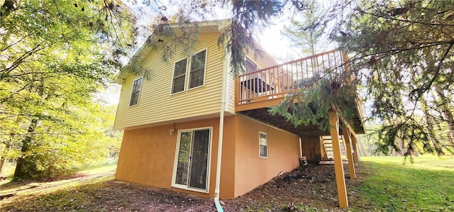 view of side of property with a wooden deck and a yard