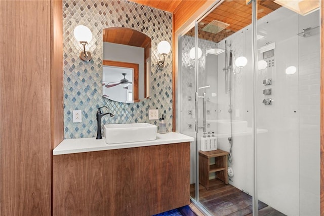 bathroom featuring wood-type flooring, vanity, tile walls, and ceiling fan