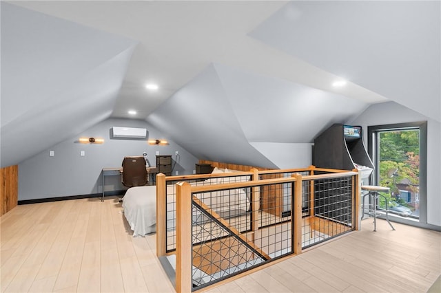 bonus room with light hardwood / wood-style floors, a wall unit AC, and lofted ceiling