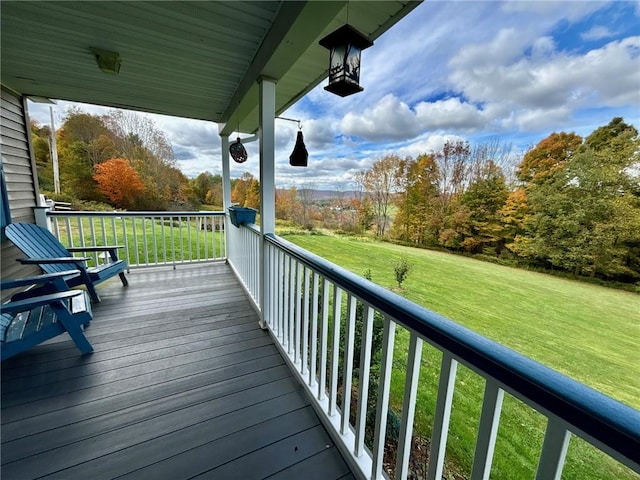 wooden deck featuring a porch and a yard